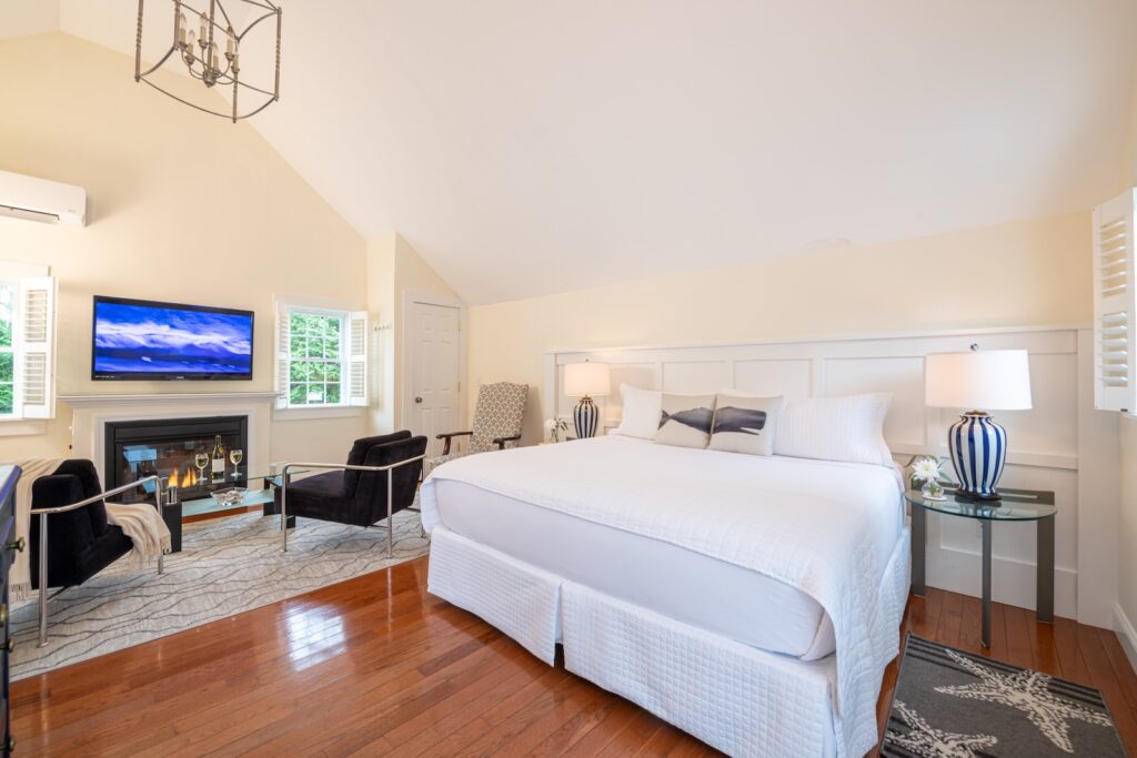 A king bed and a seating area in front of a fireplace at the best bed and breakfast Cape Cod.